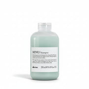 Champú Davines MINU para cabello teñido. Botella azul claro sobre fondo blanco mostrando la textura espumosa y el beneficio de protección del color, Panamá