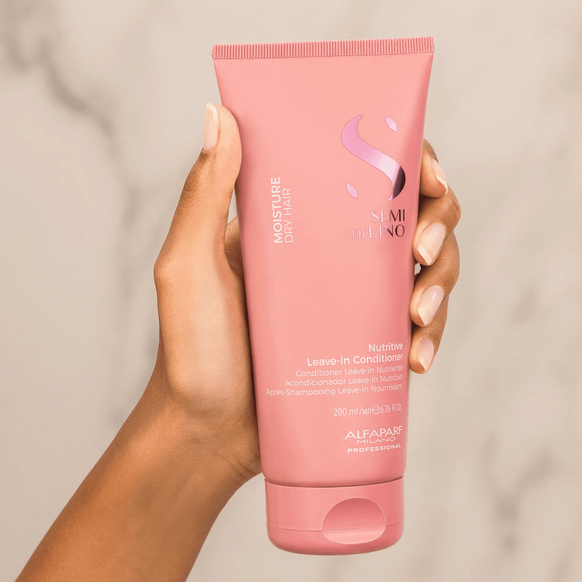 Alfaparf Semi di Lino Moisture Leave-in Conditioner 200 ml, detalle del envase en mano.