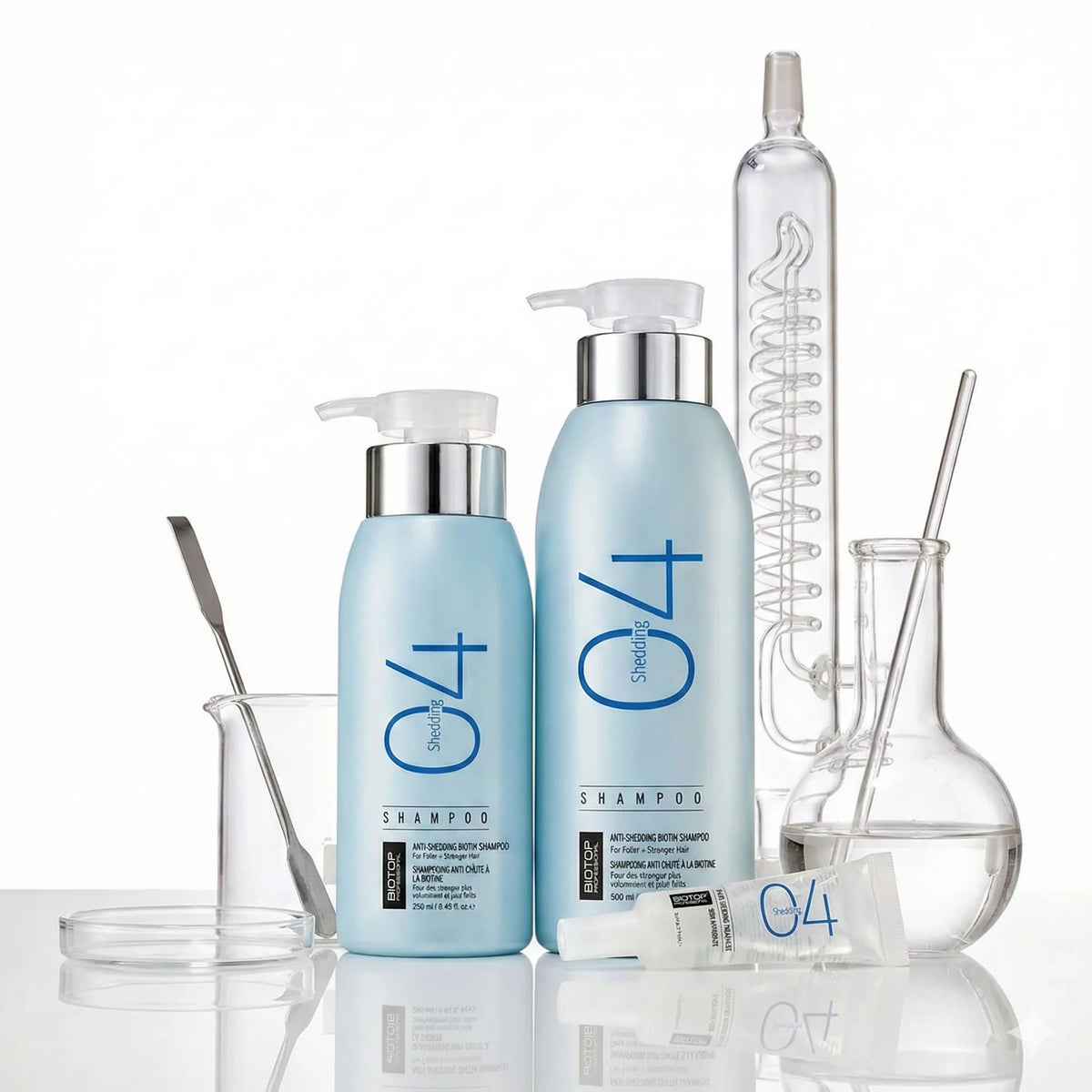 Biotop 04 Shedding Shampoo de 250 y 500 ml en botellas celestes con dispensador, junto a material de laboratorio