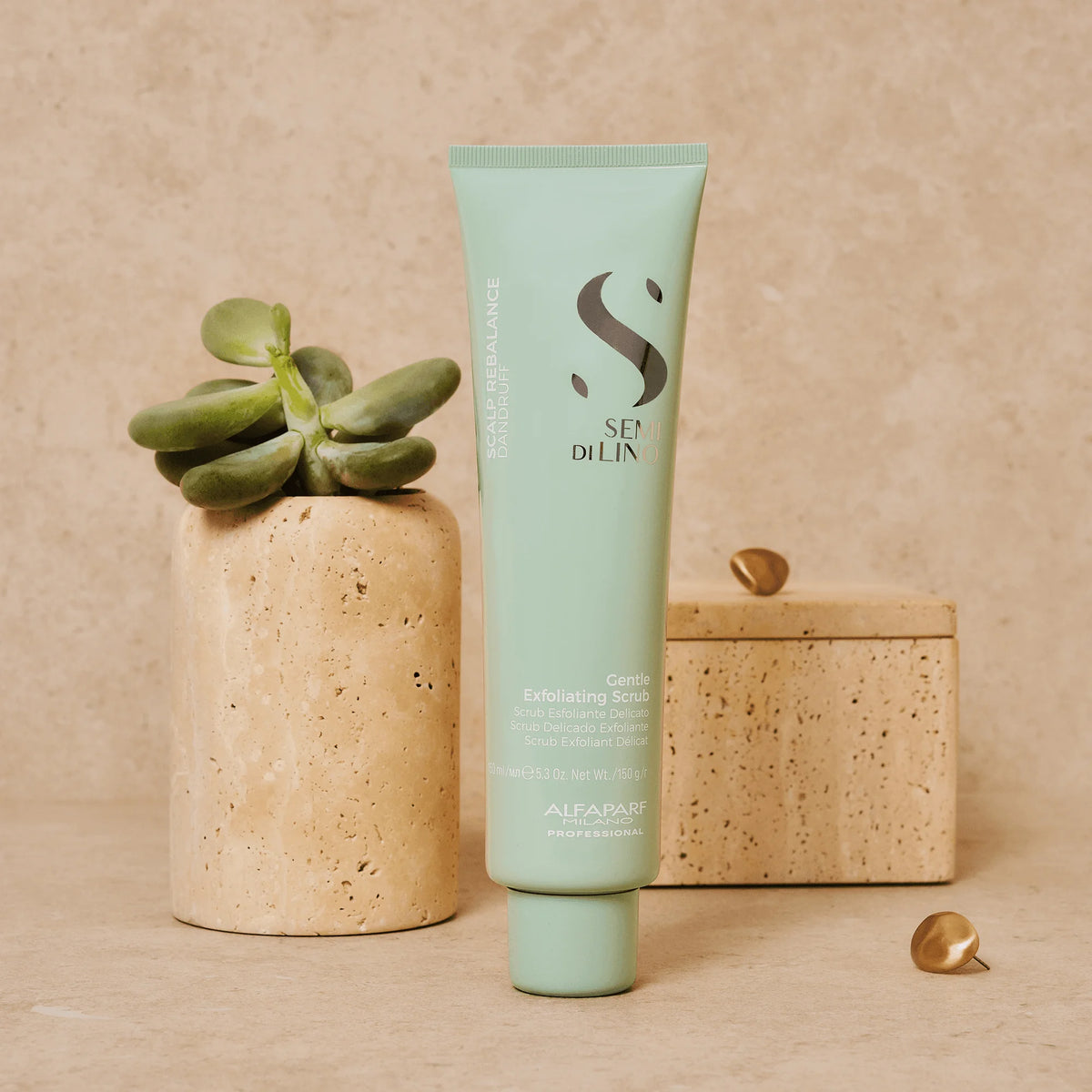  Alfaparf Semi di Lino Gentle Exfoliating Scrub 150 ml junto a una planta, gel con microgránulos para exfoliar suavemente el cuero cabelludo.

